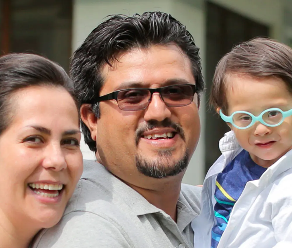 A couple smiles with their child